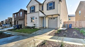 A two-story residential building with a garage, a brick section, and a well-maintained lawn. - 4 Mi to City Center: Family-friendly Retreat! (Merced)
