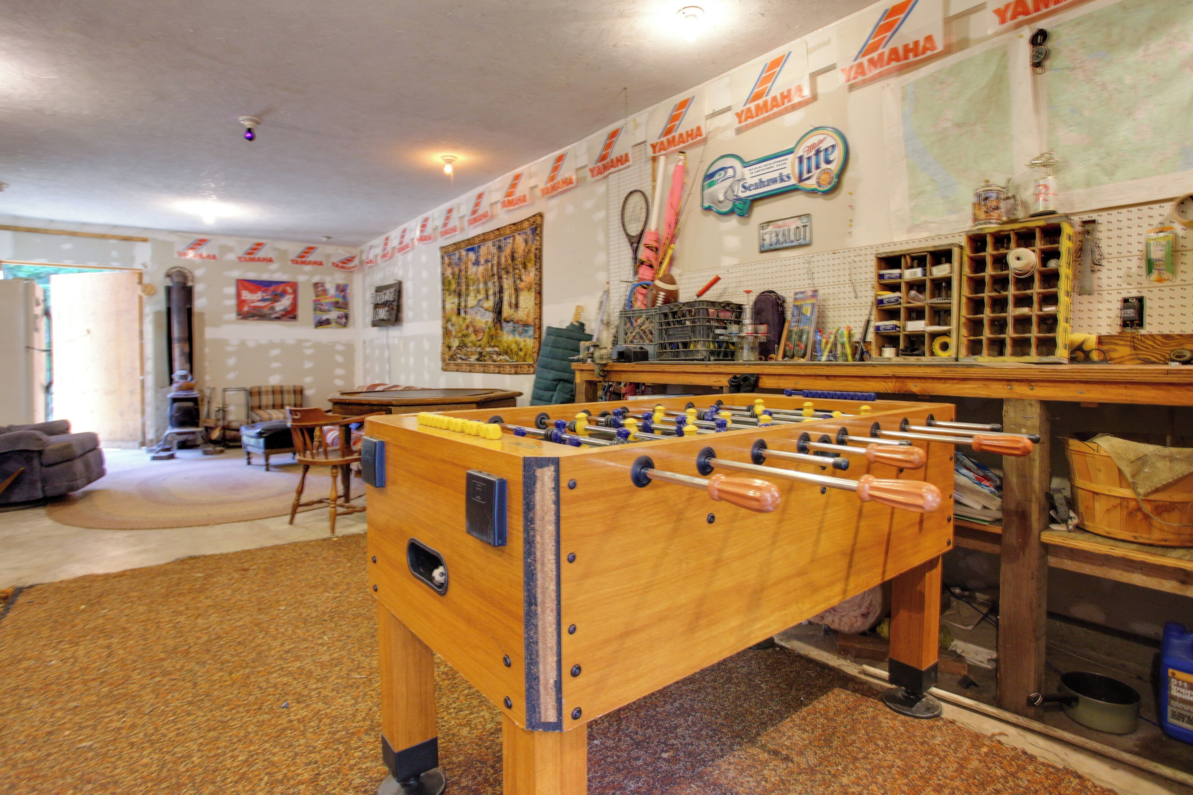 Een kamer met een tafelvoetbaltafel, een kaart aan de muur, en diverse gereedschappen en apparatuur.