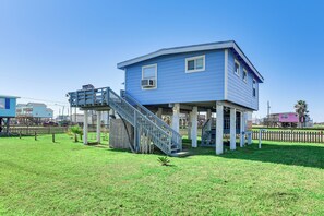 A two-story house with a blue exterior, a wooden deck, and a staircase leading to the second floor. - 1 Mi to Surfside Beach: Bbq-ready Home in Freeport (Freeport)