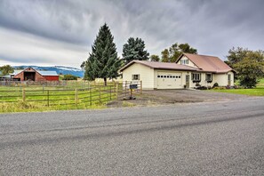 A rural property with a large house, a barn, and a fenced pasture.