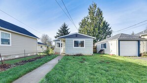 Une maison mobile de plain-pied, avec un petit jardin devant, un chemin menant à l’entrée et un garage sur le côté droit.