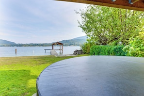 Un espace extérieur abrité offrant une vue sur un lac et des montagnes.
