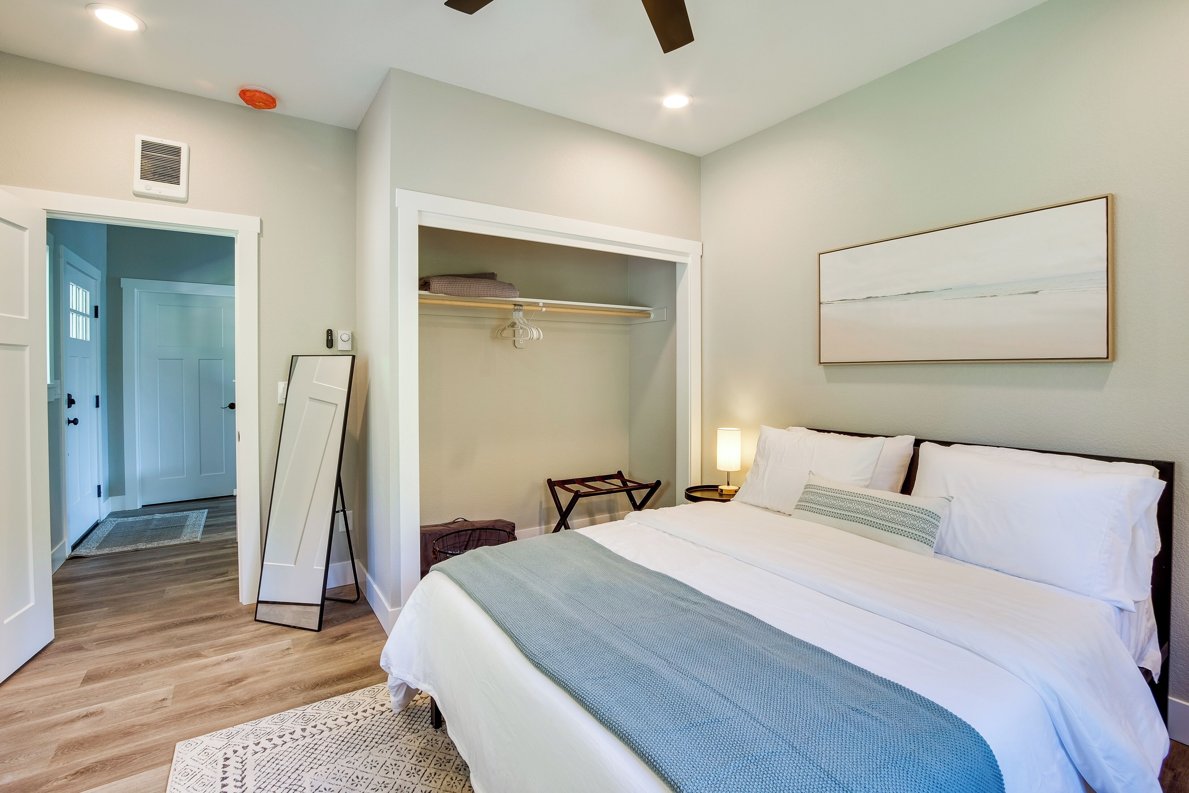 A bedroom with a bed, bedside table, and a wardrobe.