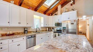 A spacious kitchen with white cabinets, granite countertops, stainless steel appliances, and a skylight. - Spacious House w/ Deck & Grill in South Lake Tahoe (South Lake Tahoe)