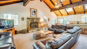 A spacious living room with leather sofas, a stone fireplace, and a television. - Spacious House w/ Deck & Grill in South Lake Tahoe (South Lake Tahoe)