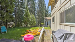 A backyard with kayaks, a paddleboard, and a covered grill. - Lake Almanor Country Club Home w/ Views! (Westwood)