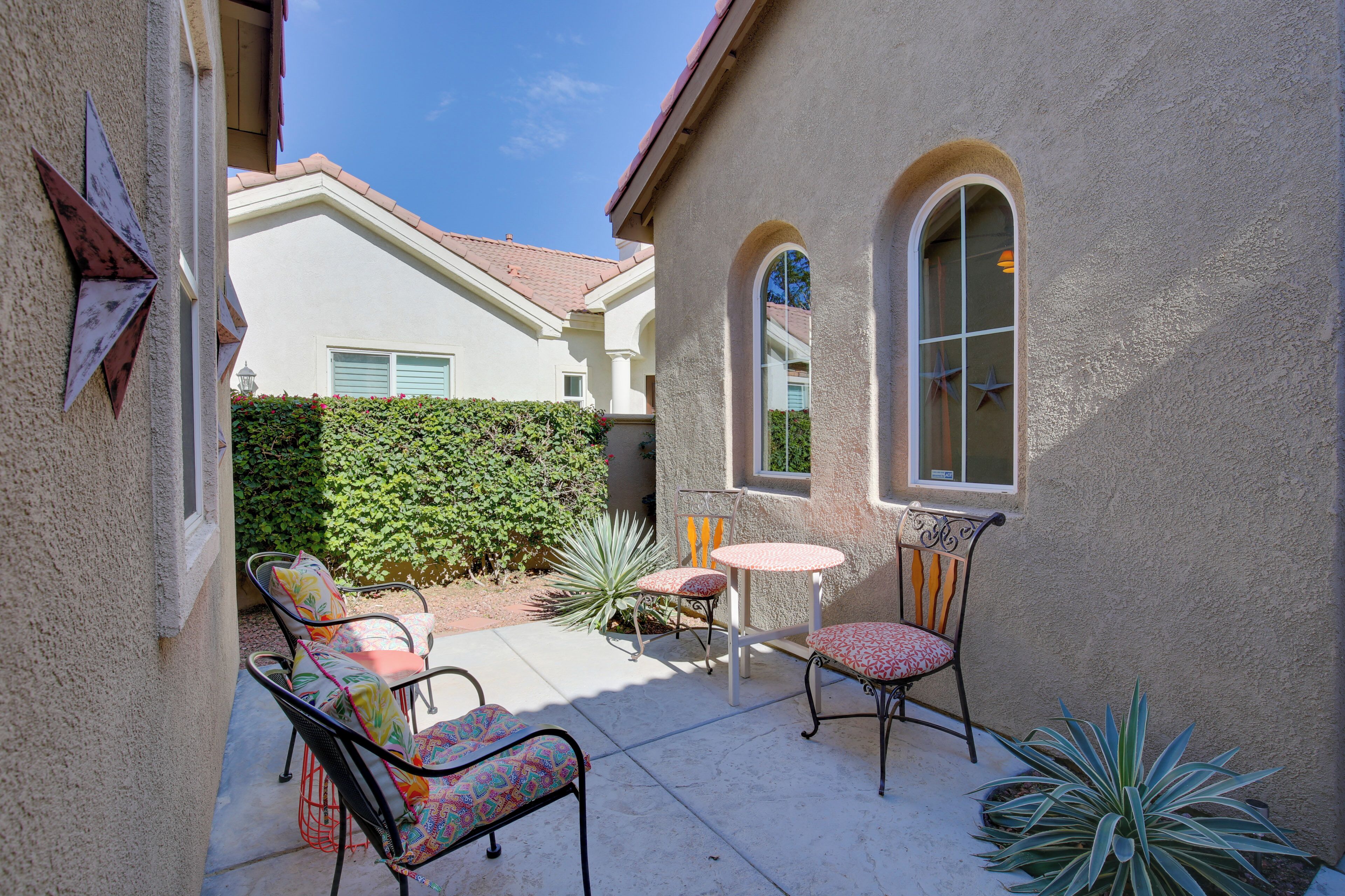 A patio with outdoor furniture, a small table, and chairs.