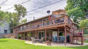A two-story house with a covered patio, outdoor furniture, and a satellite dish.