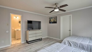 A bedroom with a ceiling fan, a TV, a dresser, and two beds. - Garland Home w/ Private Pool & Yard! (Garland)