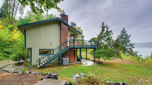 Ein eingeschossiges Haus mit einer Veranda und einer Treppe zu einem Balkon im zweiten Stock.