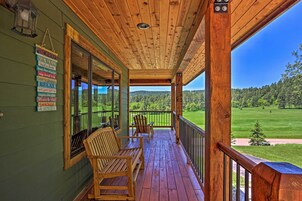 A wooden porch with a view of a green landscape.