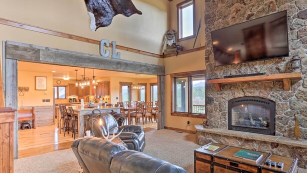 A spacious living area with a stone fireplace, leather sofas, and a dining area with wooden furniture.