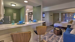 Una habitación de hotel moderna con cocina, cama y zona de estar.