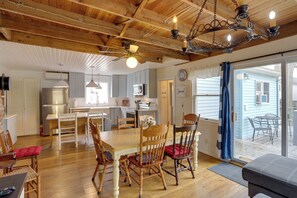 A spacious kitchen with modern appliances, a dining area with wooden chairs and a table, and a large sliding glass door leading to an outdoor patio. - Spacious Lakeside Cottage - 2 Miles to Marblehead! (Marblehead)