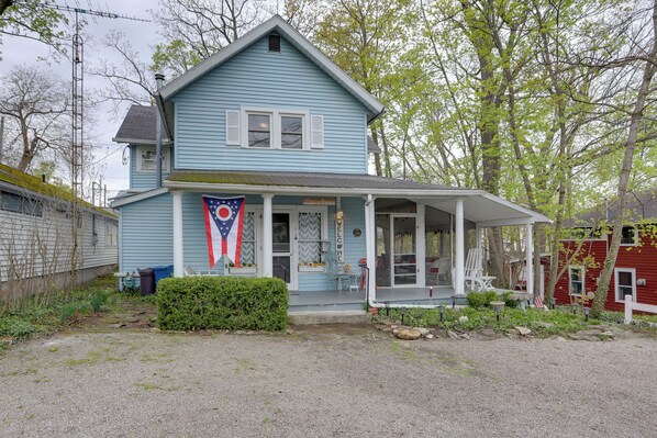 A two-story house with a porch, a welcome sign, and a flag. - Spacious Lakeside Cottage - 2 Miles to Marblehead! (Marblehead)