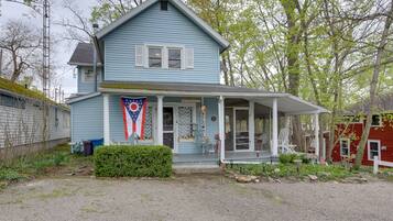 Charming two-story house with a welcoming front porch and beautifully maintained garden.