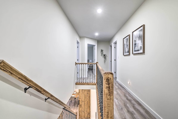 A staircase with wooden railings and a handrail, leading to a landing with a dining area. - Community Beach & Lake: Pocono Summit Escape (Pocono Summit)