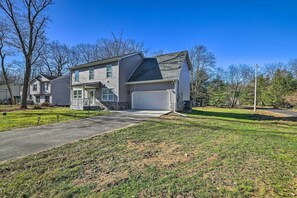 A two-story house with a garage, a front yard, and a driveway. - Community Beach & Lake: Pocono Summit Escape (Pocono Summit)