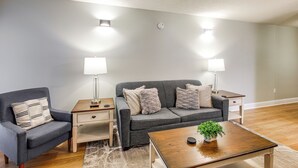 A living room with a grey sofa, two side tables with lamps, a wooden coffee table, and a patterned rug. - Gatlinburg Condo w/ Smoky Views: Walk to Town! (Gatlinburg)