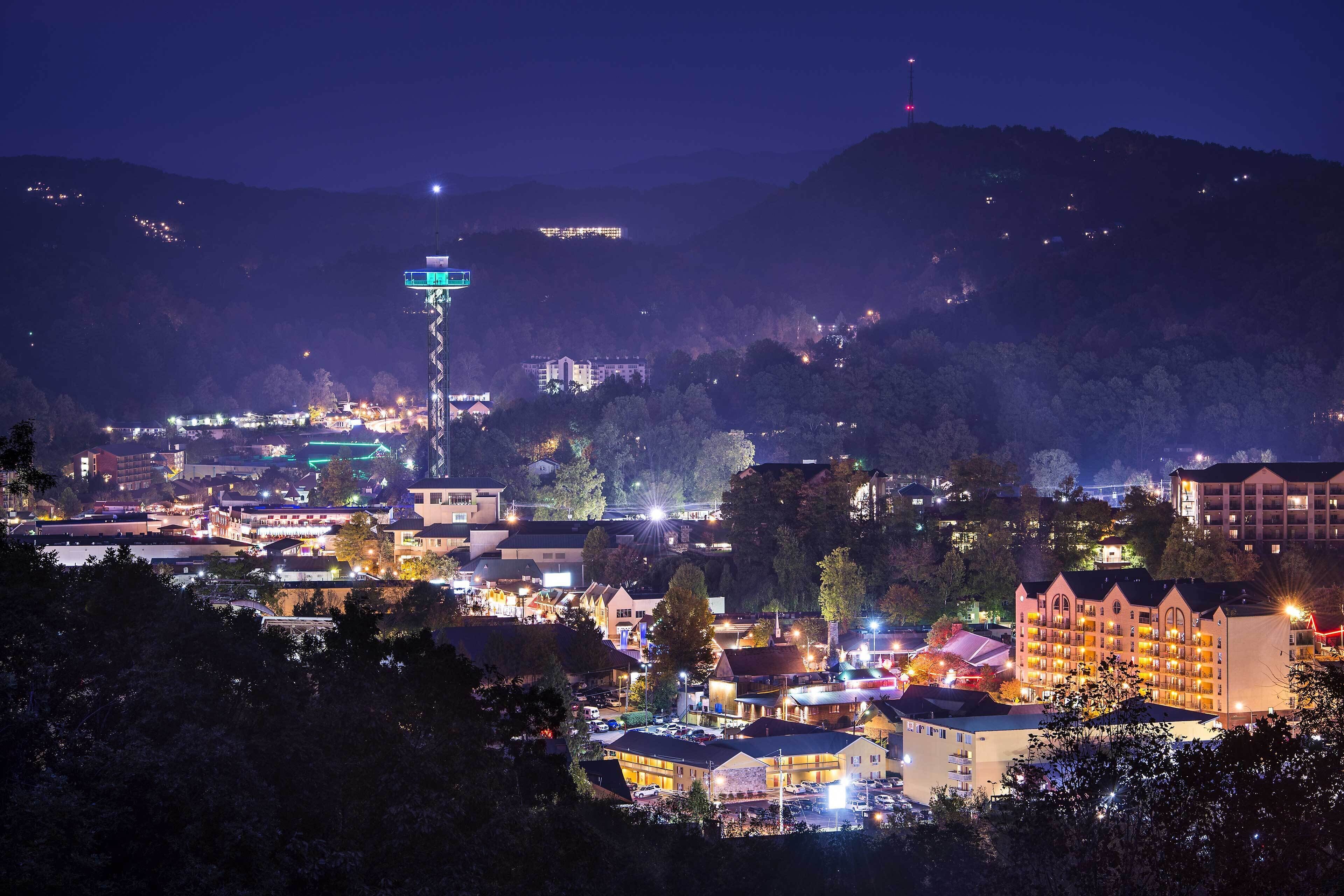 A town at night with a prominent tower and various buildings.