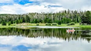 Un lac paisible, avec une petite barque et une forêt dense en arrière-plan.