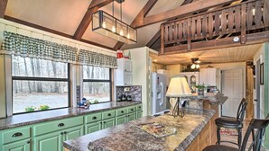 A kitchen with green cabinets, a granite countertop, and a window with a view of trees. - Douglas Lake Cabin w/ Mountain-view Deck & Grill (White Pine)