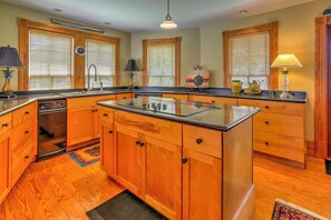 A kitchen with wooden cabinets, a central island, and a built-in oven.