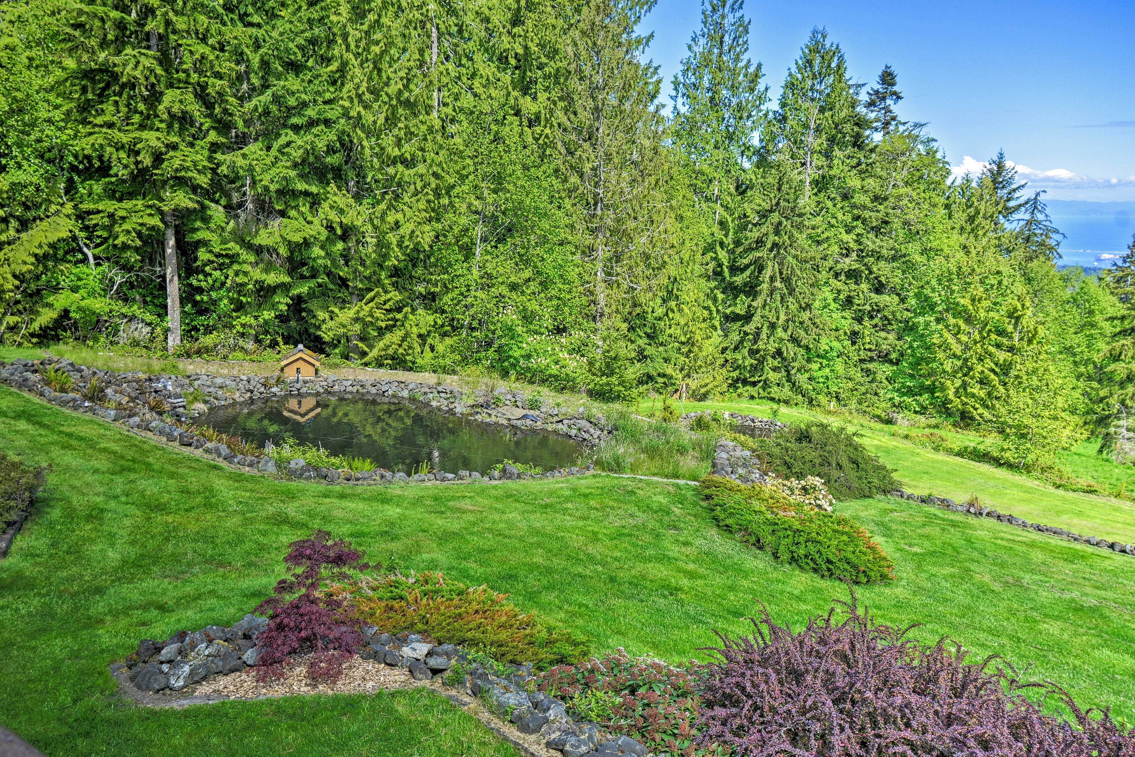 A serene garden with a pond, lush greenery, and a small wooden structure.