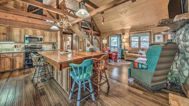 A rustic cabin interior with a wooden dining area, kitchen, and living space. - Tree-lined 'polly's Perch' w/ Mountain Views! (Ruidoso)