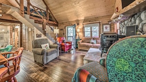 A cozy cabin interior with wooden floors, a staircase, a fireplace, and rustic furnishings. - Tree-lined 'polly's Perch' w/ Mountain Views! (Ruidoso)