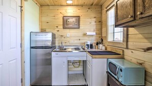 Una cocina compacta equipada con refrigerador, estufa, microondas y pileta.
