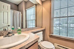 A bathroom with a sink, mirror, toilet, and window with blinds. - Tannersville Cozy Home w/ Deck, 1 Mi to Camelback! (Tannersville)