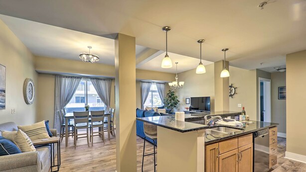 Una cocina amplia con una isla central, armarios de madera e iluminación colgante.