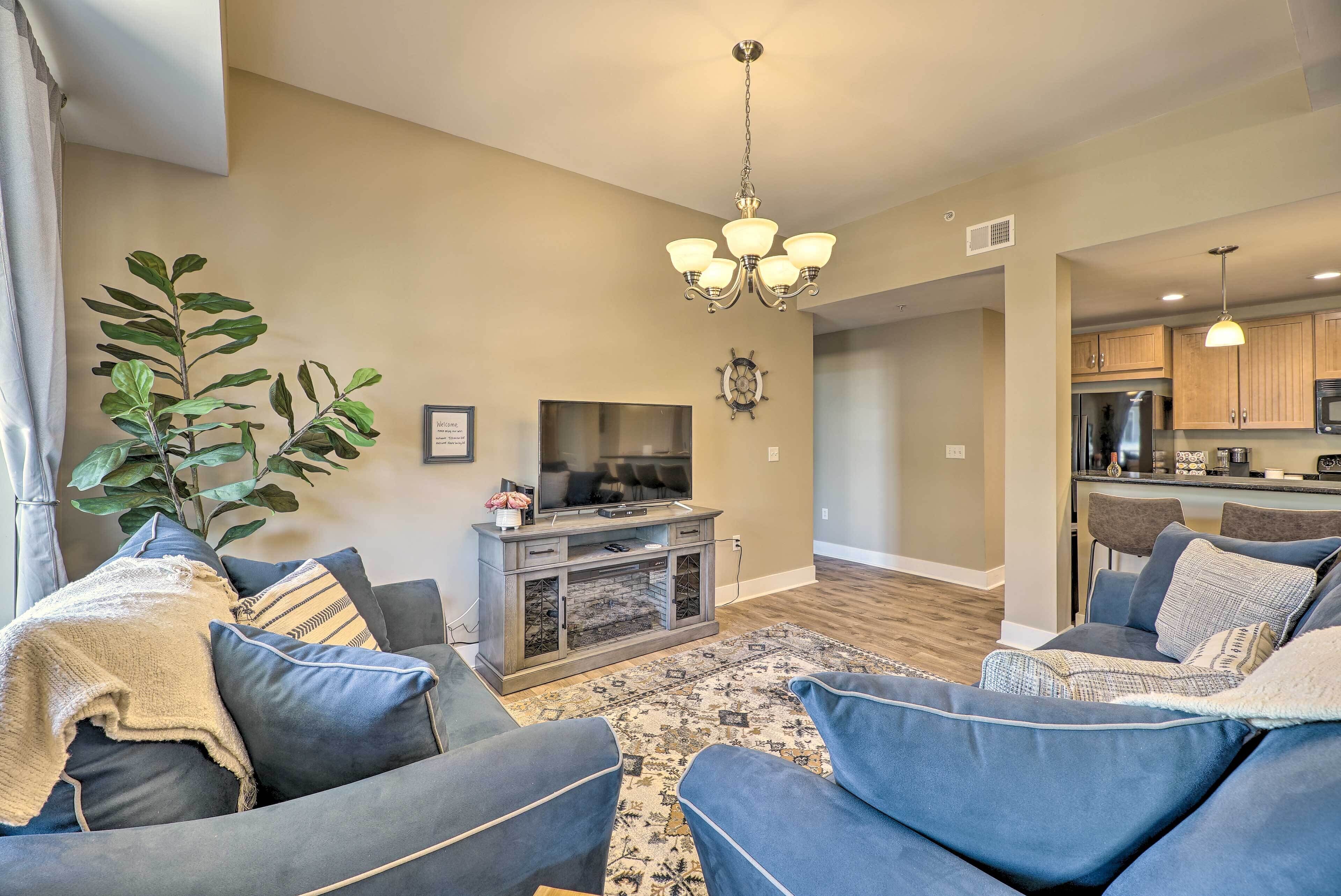 A living room with a TV, sofa, and a plant.