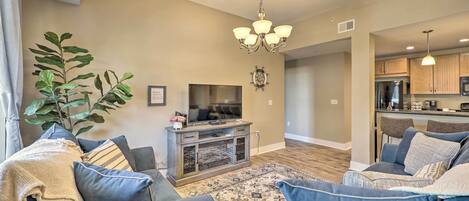 A living room with a TV, sofa, and a plant.