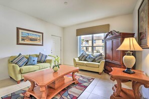 A living room with two sofas, a wooden coffee table, a lamp, and a painting on the wall. - Kissimmee Condo w/ Resort Perks - 5 Mi to Disney! (Kissimmee)