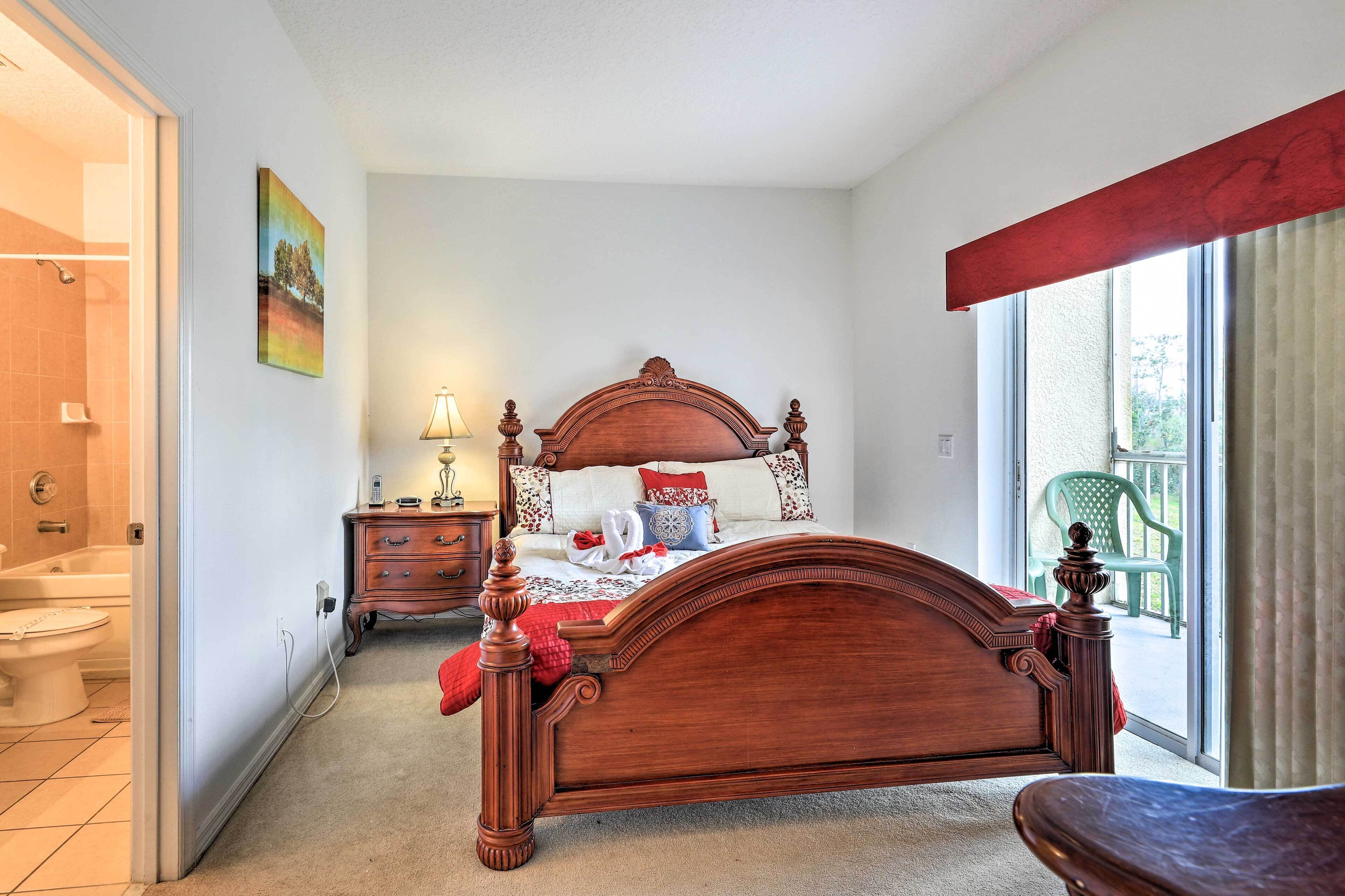 Un dormitorio con una cama de madera, una mesita de noche, una lámpara y vistas a un balcón.