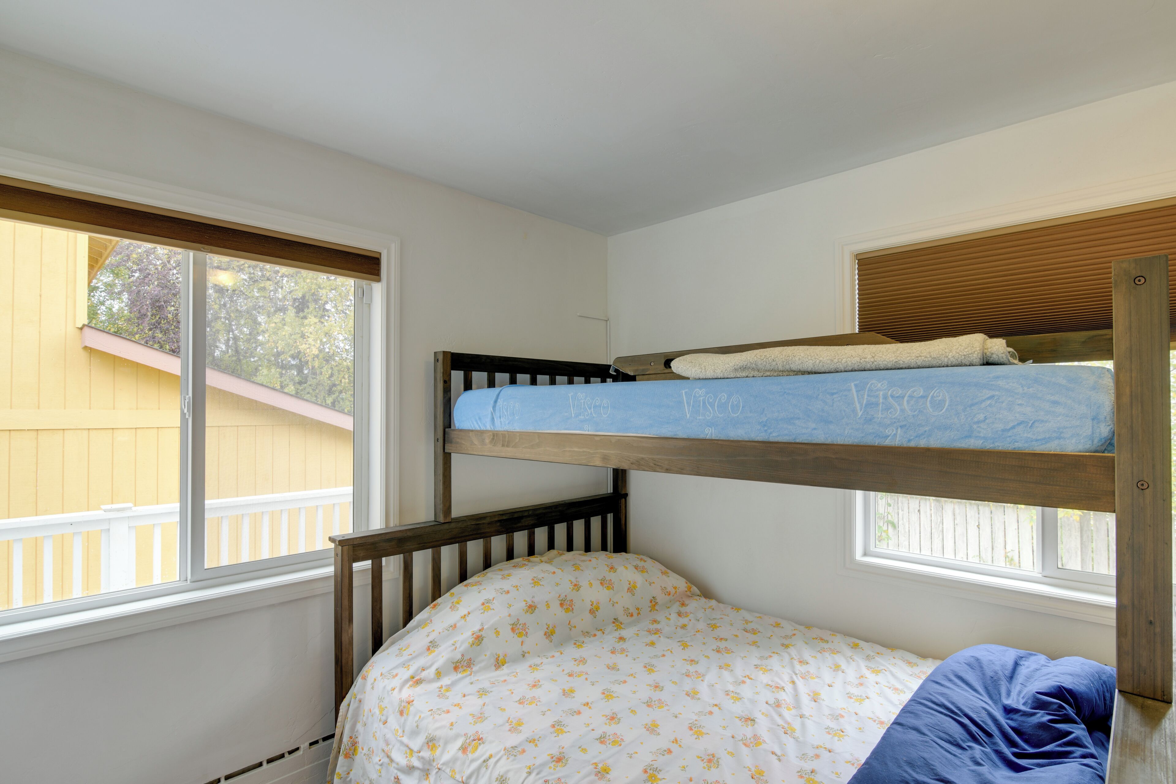 Uma cama beliche com uma cama inferior e uma janela acima.