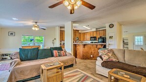 A spacious living room with two sofas, a coffee table, and a ceiling fan.