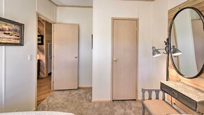 Un dormitorio con un armario de madera, un espejo y una mesita de noche.