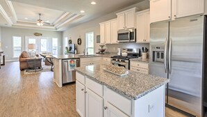 A spacious kitchen with granite countertops, stainless steel appliances, and white cabinetry. - Port St Joe Beach House w/ Pool Access! (Port St. Joe)