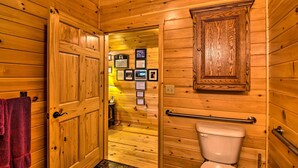 Et træinteriør med en trædør, et toilet og et skab i træ.