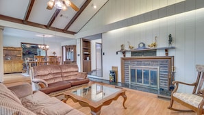A spacious living room with a fireplace, wooden furniture, and a kitchen in the background. - Gassville Home 3 Mi to White River & Trout Fishing (Gassville)