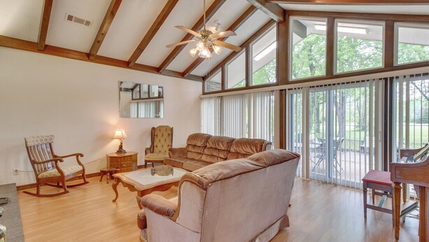 A spacious living room with a large sofa, a wooden coffee table, and a rocking chair. There is a piano and a mirror on the wall. - Gassville Home 3 Mi to White River & Trout Fishing (Gassville)