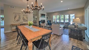 Un salon spacieux avec une grande table à manger en bois, des sièges confortables et une cheminée.