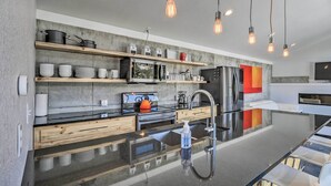 A modern kitchen with wooden shelves, a stainless steel refrigerator, and a black countertop. - Winters Gold in Alma: Big Views, 15 Mi to Breck (Alma)