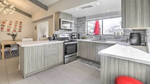 A modern kitchen with a central island, stainless steel appliances, and a large window. - Sleek Rancho Mirage Villa: Patio, Pool, Golf! (Rancho Mirage)