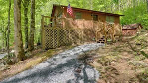 Eine Holzhütte mit einer Holzterrasse und einer Treppe, sowie einer amerikanischen Flagge.