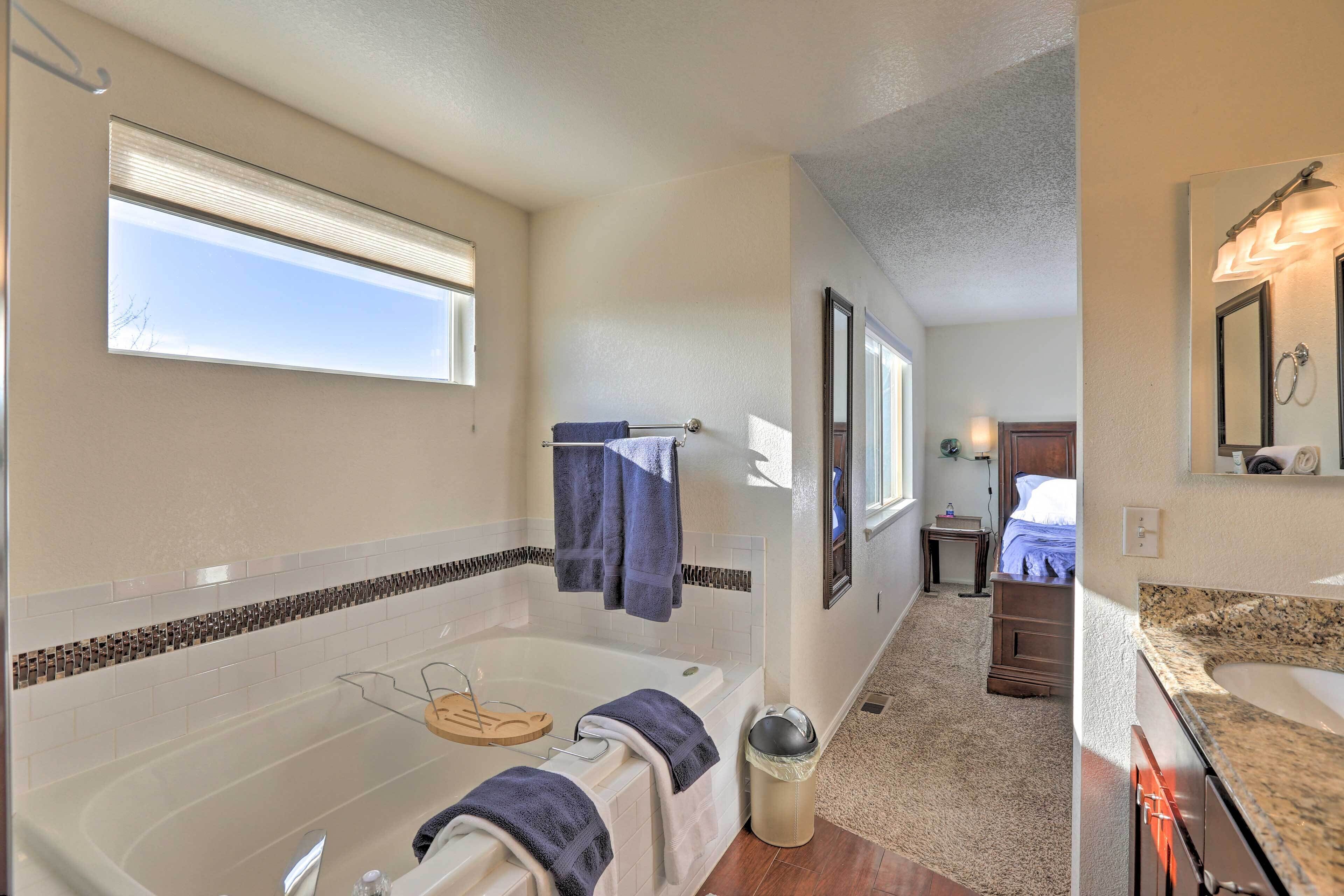 A bathroom with a bathtub, a sink, and a window.
