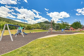 A playground with swings, slides, and climbing structures. - Avon Duplex w/ Hot Tub: Ski Vail & Beaver Creek! (Avon)